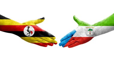 Ellere boyanmış Ekvator Ginesi ve Uganda bayrakları arasındaki el sıkışma, izole şeffaf görüntü.