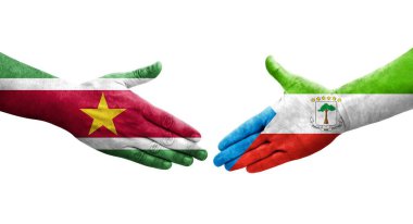 Ellere boyanmış Ekvator Ginesi ve Surinam bayrakları arasındaki el sıkışma, izole şeffaf görüntü.