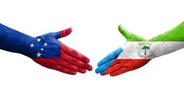 Ellere boyanmış Ekvator Ginesi ve Samoa bayrakları arasındaki el sıkışma, izole şeffaf görüntü.