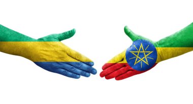 Etiyopya ve Gabon bayrakları arasındaki tokalaşma elleri boyalı, izole şeffaf görüntü.
