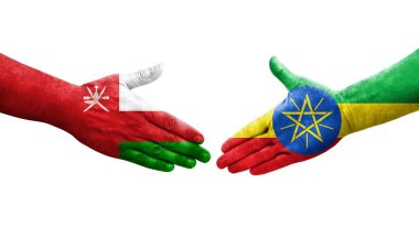 Etiyopya ve Umman bayrakları arasındaki tokalaşma elleri boyalı, izole şeffaf görüntü.