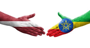Etiyopya ve Letonya bayrakları arasındaki tokalaşma elleri boyalı, izole şeffaf resim.