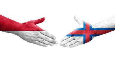 Faroe Adaları ve Monako bayrakları arasındaki el sıkışma ellerinde izole şeffaf görüntü.