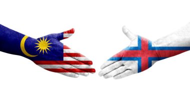 Ellerinde Faroe Adaları ve Malezya bayrakları arasında el sıkışma, izole şeffaf görüntü.