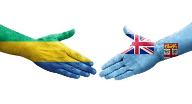 Fiji ve Gabon bayrakları arasındaki tokalaşma elleri boyalı, izole şeffaf görüntü.