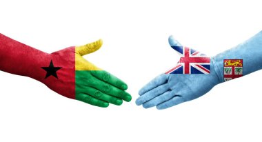 Fiji ve Gine Bissau bayrakları arasındaki tokalaşma ellerinde izole şeffaf görüntü.