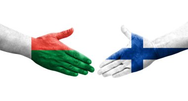 Finlandiya ile Madagaskar bayrakları arasındaki el sıkışma ellerde resmedilmiş, izole edilmiş şeffaf görüntü.