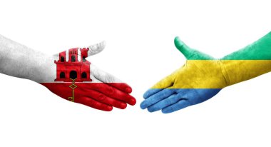 Gabon ve Cebelitarık bayrakları arasındaki el sıkışma ellerinde izole şeffaf görüntü.