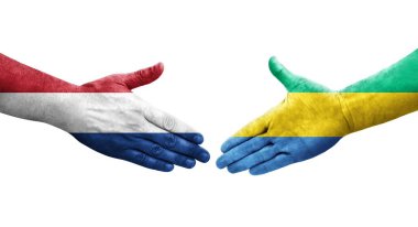 Gabon ve Hollanda bayrakları arasındaki el sıkışma ellerinde resmedilmiş şeffaf görüntü.