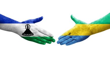 Gabon ve Lesotho bayrakları arasındaki el sıkışma ellerinde izole şeffaf görüntü.