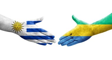 Gabon ve Uruguay bayrakları arasındaki el sıkışma ellerinde izole şeffaf görüntü.