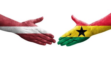 Gana ve Letonya bayrakları arasındaki el sıkışma ellerinde resmedilmiş şeffaf görüntü.