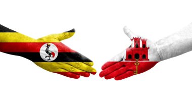 Cebelitarık ve Uganda bayrakları arasındaki el sıkışma ellerinde izole şeffaf görüntü.