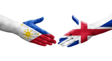 Büyük Britanya ve Filipinler arasındaki el sıkışma ellerinde boyanmış bayraklar, yalıtılmış şeffaf görüntü.