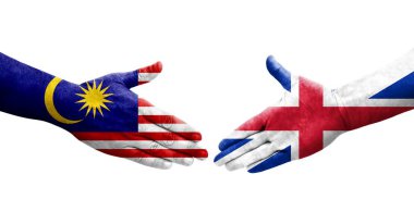 Büyük Britanya ve Malezya bayrakları arasındaki el sıkışma ellerinde resmedilmiş şeffaf görüntü.