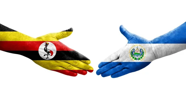 stock image Handshake between El Salvador and Uganda flags painted on hands, isolated transparent image.