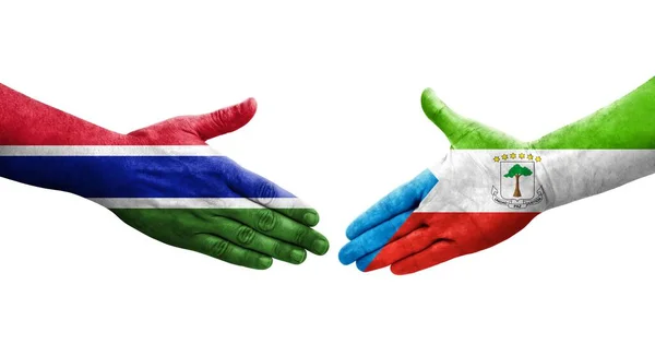 stock image Handshake between Equatorial Guinea and Gambia flags painted on hands, isolated transparent image.