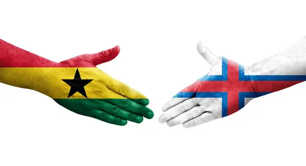 Stock image Handshake between Faroe Islands and Ghana flags painted on hands, isolated transparent image.