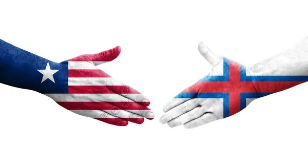 Uścisk Dłoni Między Wyspami Owczymi Flagami Liberii Namalowanymi Rękach Odizolowany — Zdjęcie stockowe