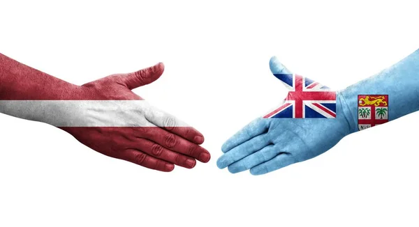 Poignée Main Entre Fidji Lettonie Drapeaux Peints Sur Les Mains — Photo