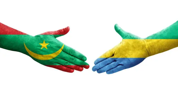 stock image Handshake between Gabon and Mauritania flags painted on hands, isolated transparent image.