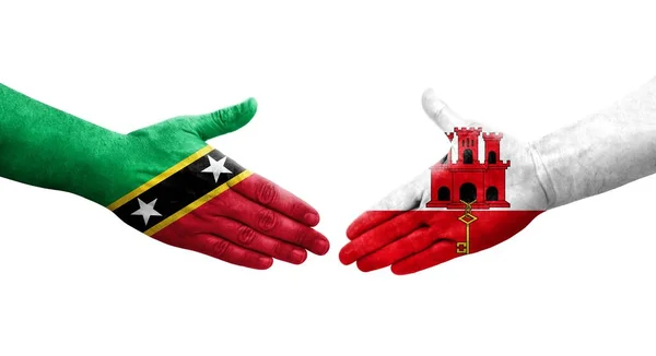 Håndtrykk Mellom Gibraltar Saint Kitts Nevis Flaggene Malt Hendene Isolert – stockfoto