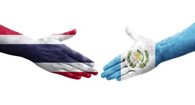 Guatemala ve Tayland bayrakları arasındaki el sıkışma ellerinde izole şeffaf görüntü.
