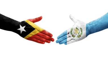 Guatemala ve Timor Leste bayrakları arasındaki el sıkışma ellerinde izole şeffaf görüntü.