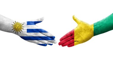 Gine ve Uruguay bayrakları arasındaki el sıkışma ellerinde izole şeffaf görüntü.
