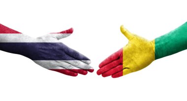 Gine ve Tayland bayrakları arasındaki el sıkışma ellerinde resmedilmiş şeffaf görüntü.