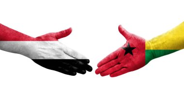 Ellerinde Gine Bissau ve Yemen bayrakları arasında el sıkışma, izole şeffaf görüntü.