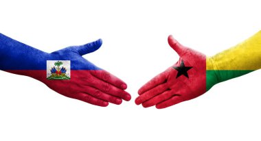 Ellerinde Gine Bissau ve Haiti bayrakları arasında el sıkışma, izole şeffaf görüntü.
