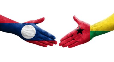 Ellerinde Gine Bissau ve Laos bayrakları arasında el sıkışma, izole şeffaf görüntü.