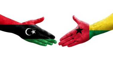 Gine Bissau ve Libya bayrakları arasındaki el sıkışma, izole şeffaf görüntü.