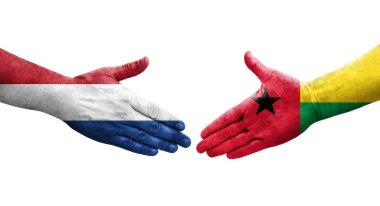 Gine Bissau ve Hollanda bayrakları arasındaki el sıkışma, izole şeffaf görüntü.