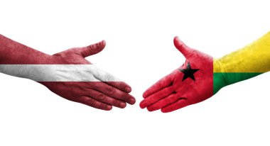Gine Bissau ve Letonya bayrakları arasındaki el sıkışma, izole şeffaf görüntü.