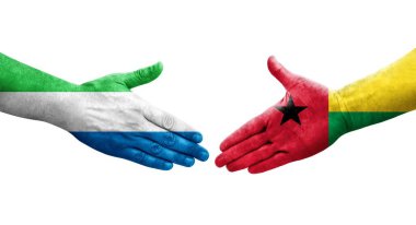 Ellerinde Gine Bissau ve Sierra Leone bayrakları arasında el sıkışma, izole şeffaf görüntü.