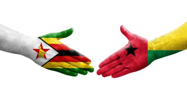 Ellerinde Gine Bissau ve Zimbabwe bayrakları arasında el sıkışma, izole şeffaf görüntü.