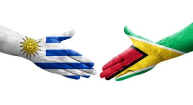 Guyana ve Uruguay bayrakları arasındaki el sıkışma ellerinde izole şeffaf görüntü.
