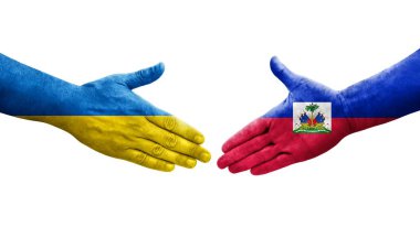 Haiti ve Ukrayna bayrakları arasındaki el sıkışma, izole şeffaf görüntü.