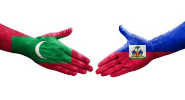 Haiti ve Maldivler arasındaki el sıkışma ellerinde boyanmış bayraklar, izole edilmiş şeffaf görüntü.