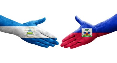 Haiti ve Nikaragua bayrakları arasındaki el sıkışma ellerinde resmedilmiş şeffaf görüntü.