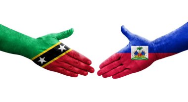 Haiti ve Saint Kitts ve Nevis bayrakları arasındaki el sıkışma ellerinde izole şeffaf görüntü.