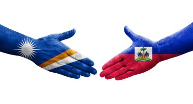 Haiti ve Marshall Adaları arasındaki el sıkışma ellerinde boyanmış bayraklar, yalıtılmış şeffaf görüntü.