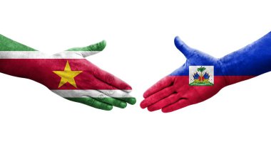 Haiti ve Surinam bayrakları arasındaki el sıkışma ellerinde boyanmış, izole şeffaf görüntü.