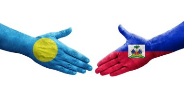 Haiti ve Palau bayrakları arasındaki el sıkışma ellerinde resmedilmiş şeffaf görüntü.