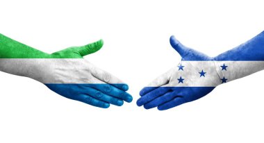 Honduras ve Sierra Leone bayrakları arasındaki el sıkışma ellerinde izole şeffaf görüntü.