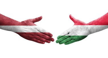 Ellerinde Macaristan ve Letonya bayrakları arasında el sıkışma, izole şeffaf görüntü.