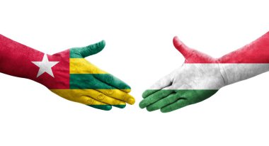 Ellerinde Macaristan ve Togo bayrakları arasında el sıkışma, izole şeffaf görüntü.