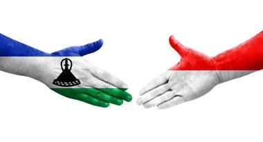 Ellerinde Endonezya ve Lesotho bayrakları arasında el sıkışma, izole şeffaf görüntü.